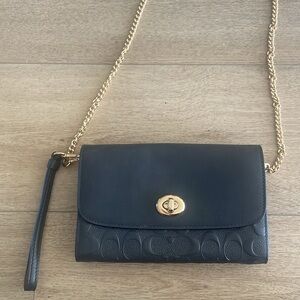 Coach wallet with chain strap and wrist strap.
